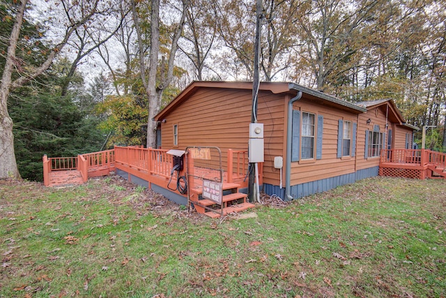 view of side of home with a lawn and a deck