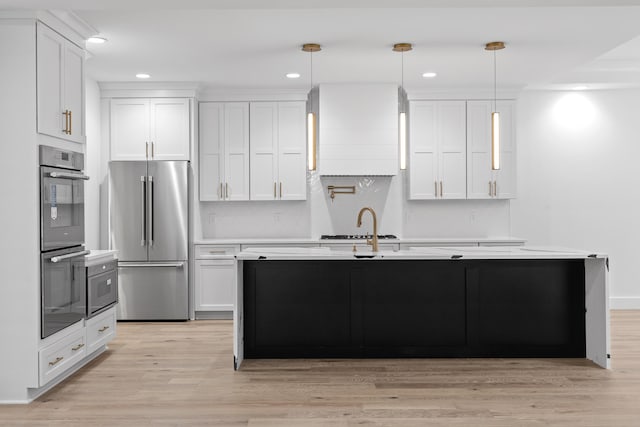 kitchen with white cabinetry, light wood-type flooring, appliances with stainless steel finishes, and pendant lighting