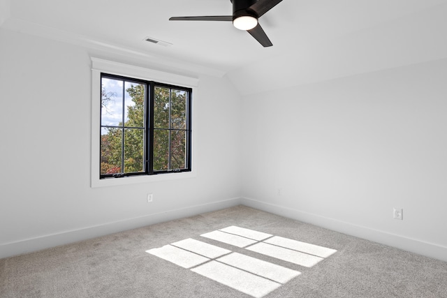 spare room featuring vaulted ceiling, light colored carpet, and ceiling fan