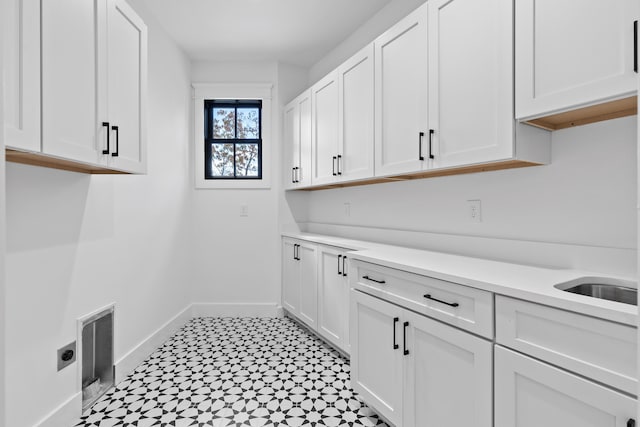 laundry room with cabinets, hookup for an electric dryer, and sink