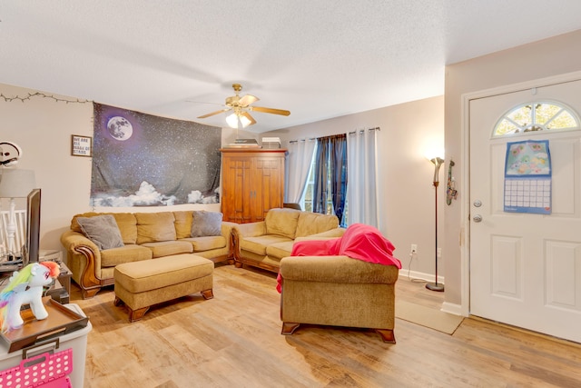 living room with a textured ceiling, hardwood / wood-style flooring, and ceiling fan