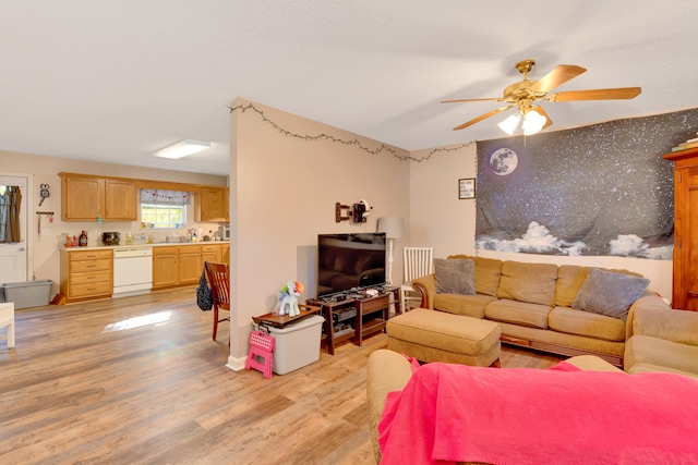 living room with sink, light wood-type flooring, and ceiling fan