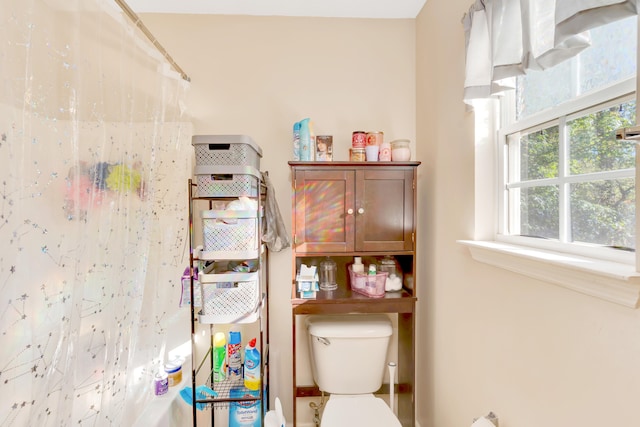 bathroom featuring curtained shower and toilet