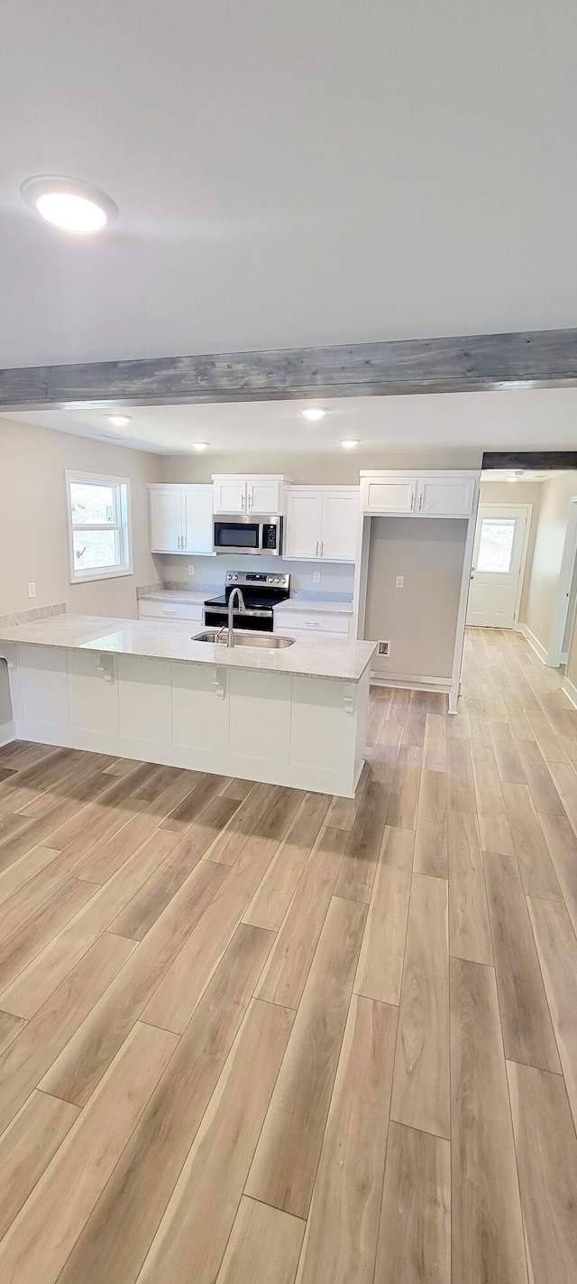 kitchen featuring white cabinetry, light hardwood / wood-style floors, beamed ceiling, and appliances with stainless steel finishes