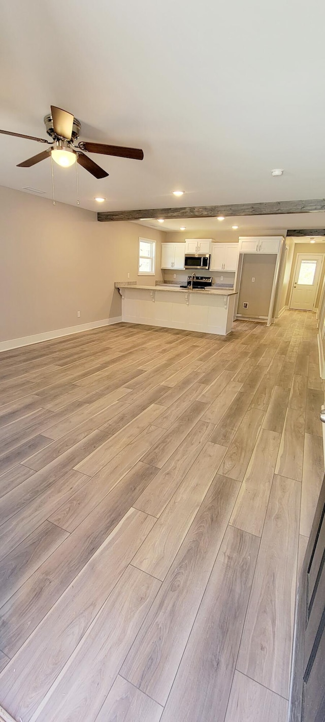 unfurnished living room with light hardwood / wood-style floors and ceiling fan