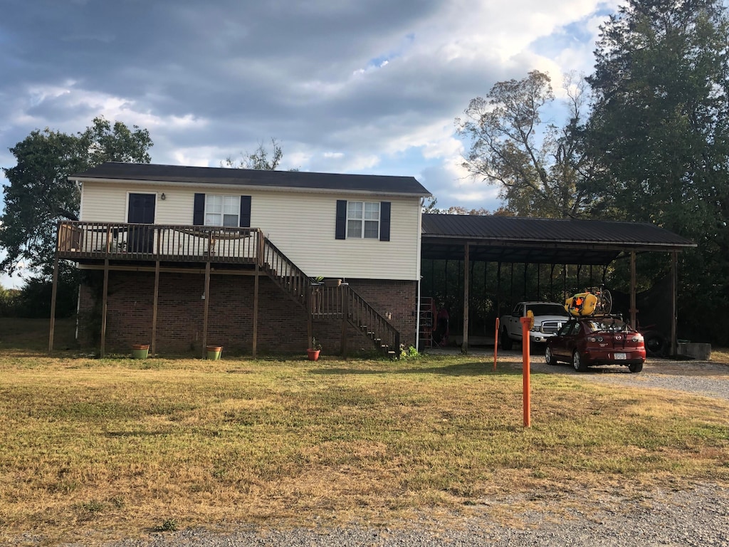 view of front of home with a deck and a front lawn