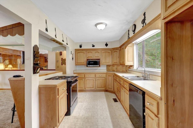 kitchen featuring a kitchen bar, appliances with stainless steel finishes, sink, and light brown cabinetry