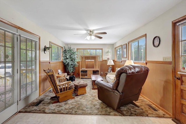 living room with wood walls and ceiling fan