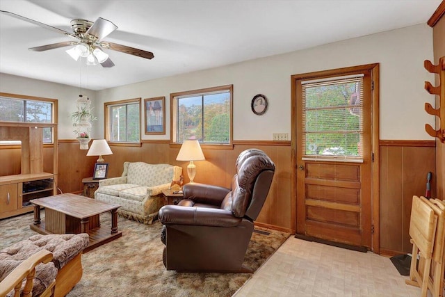 living room with wood walls and ceiling fan