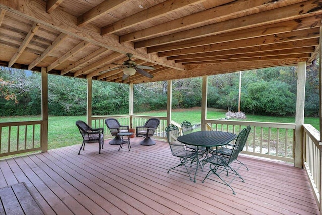 wooden terrace featuring ceiling fan and a yard