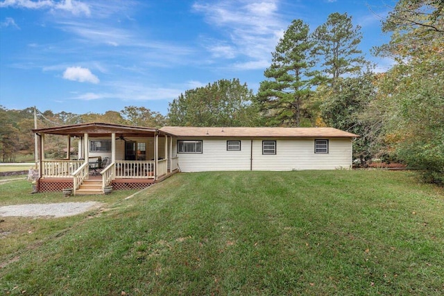 rear view of property featuring a lawn