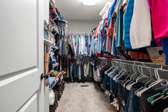 walk in closet with carpet