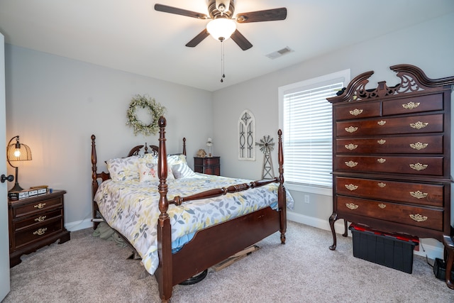 bedroom with baseboards, visible vents, a ceiling fan, and light colored carpet