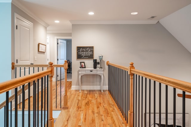 hall with recessed lighting, visible vents, an upstairs landing, ornamental molding, and light wood finished floors