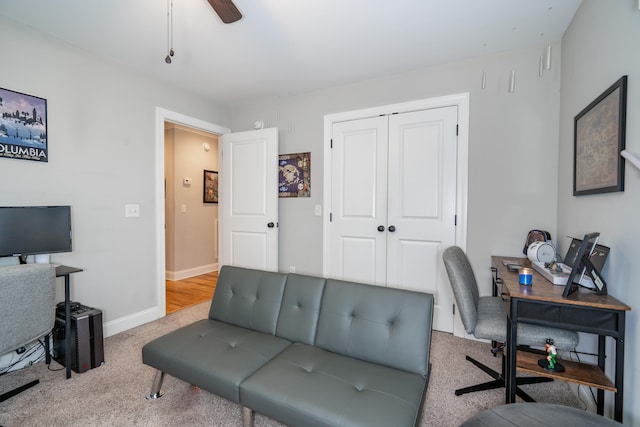 carpeted home office featuring baseboards and a ceiling fan