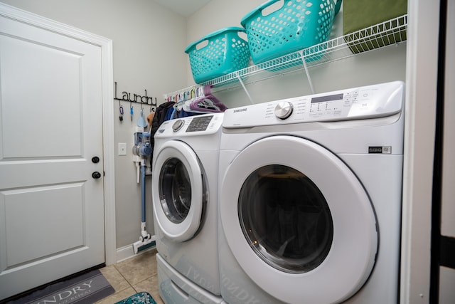 laundry room with laundry area, washing machine and clothes dryer, and light tile patterned floors