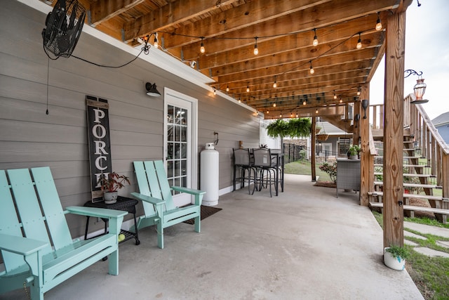 view of patio / terrace featuring stairs and fence