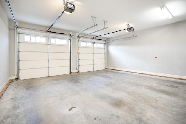 garage with baseboards and a garage door opener