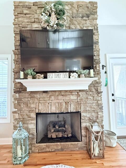 room details with a fireplace, wood finished floors, and baseboards