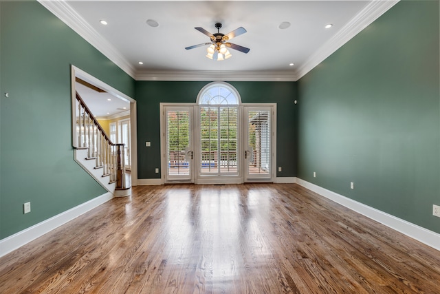 unfurnished room featuring hardwood / wood-style flooring, ceiling fan, and crown molding