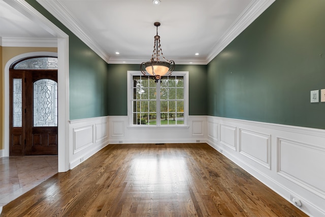 unfurnished dining area with ornamental molding and dark wood-type flooring