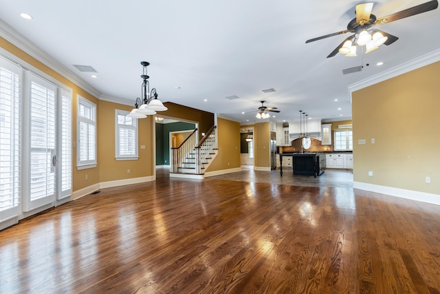 unfurnished living room featuring dark wood-type flooring, ceiling fan with notable chandelier, and crown molding