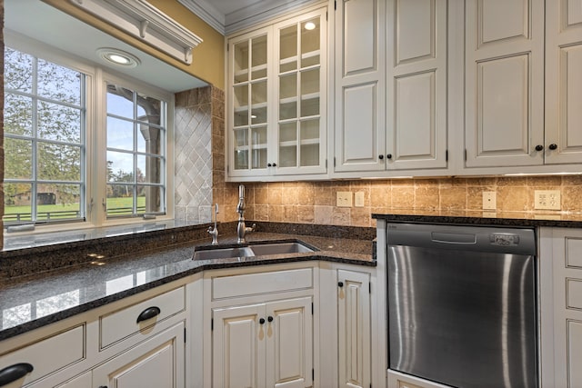 kitchen with sink, dark stone counters, stainless steel dishwasher, crown molding, and white cabinets