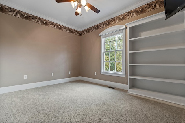 unfurnished room with ornamental molding, carpet, and ceiling fan