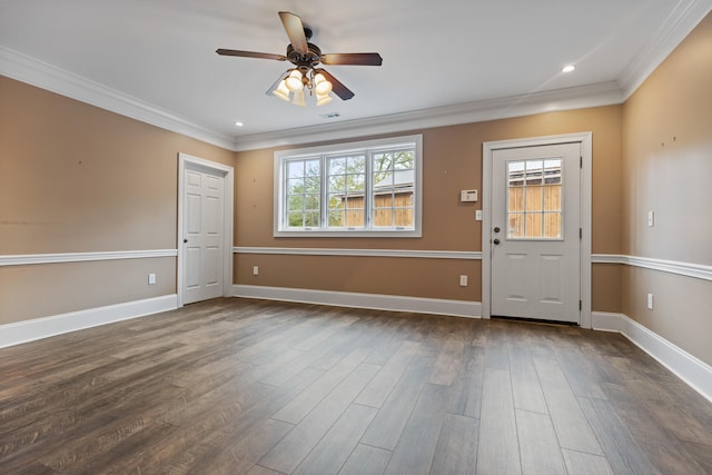 foyer entrance with dark wood-type flooring, a wealth of natural light, and ornamental molding