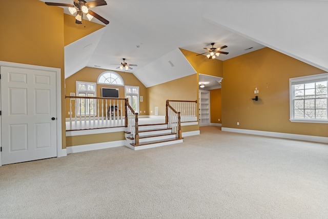 unfurnished living room with lofted ceiling, carpet flooring, and plenty of natural light