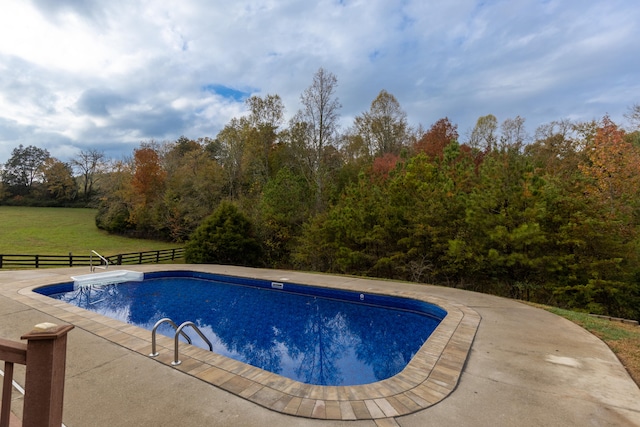 view of pool with a lawn and a patio