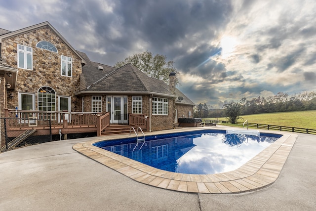 view of pool featuring a patio area and a wooden deck