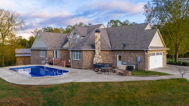 pool at dusk featuring central air condition unit, a wooden deck, and a yard