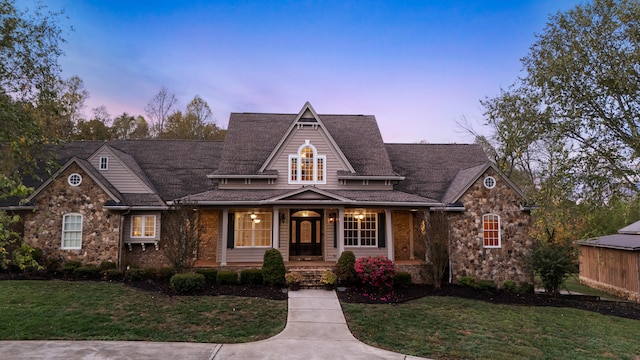 view of front of property with a porch and a yard