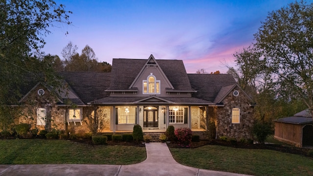 view of front of house with covered porch and a yard