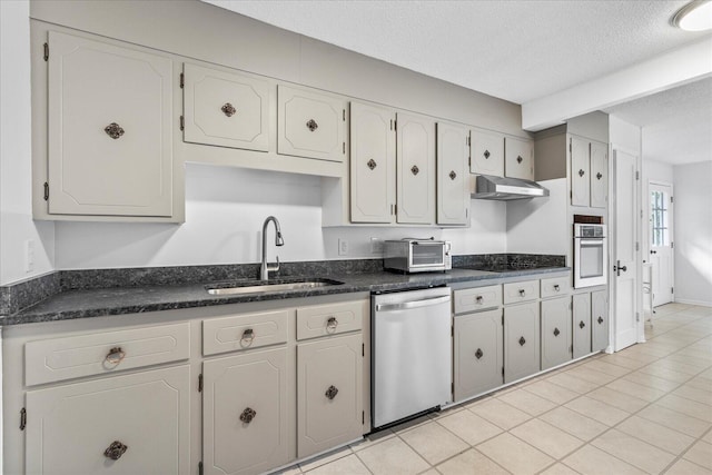 kitchen featuring white cabinetry, sink, appliances with stainless steel finishes, a textured ceiling, and light tile patterned floors