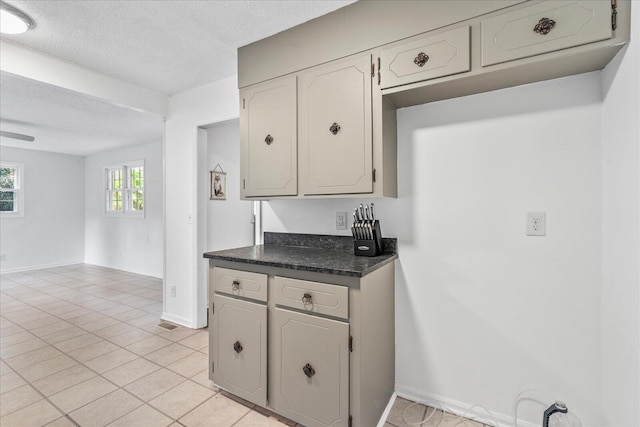 kitchen with a textured ceiling and light tile patterned floors