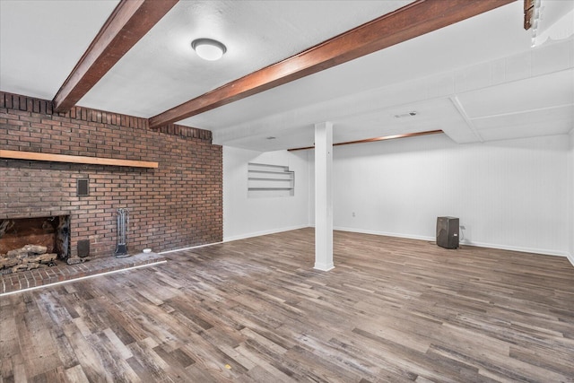 basement featuring hardwood / wood-style floors and brick wall