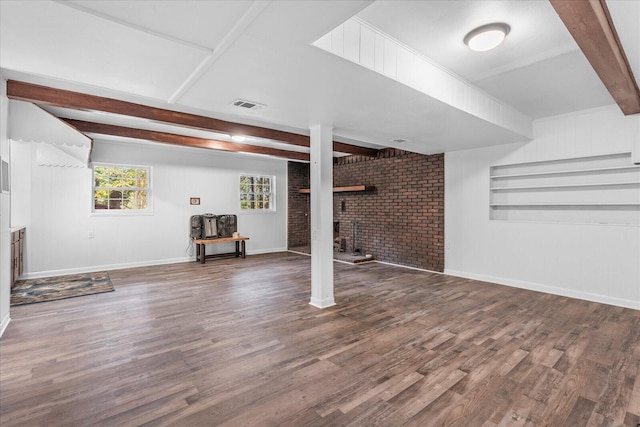 basement with wood-type flooring and brick wall