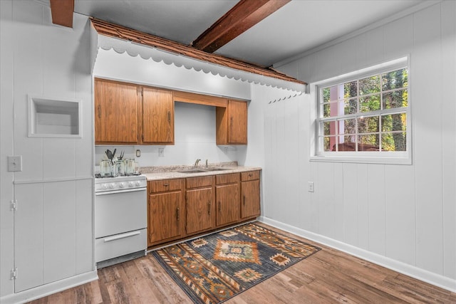 kitchen with beam ceiling, wood walls, sink, light hardwood / wood-style floors, and white stove