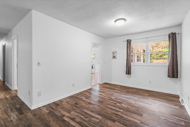 unfurnished room with dark hardwood / wood-style flooring and a textured ceiling