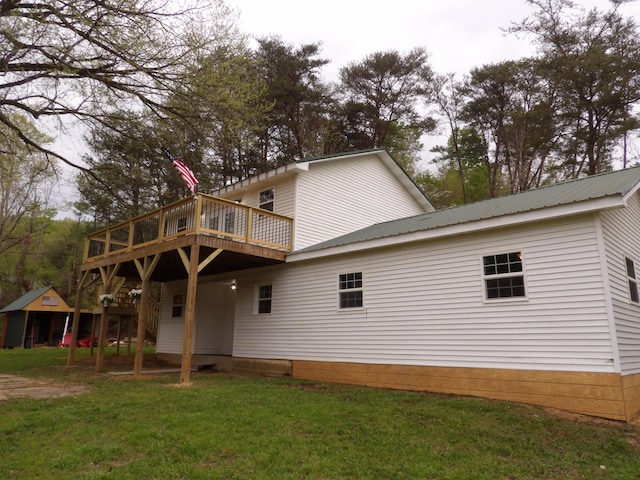 rear view of house with a wooden deck and a yard