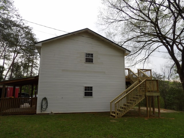 view of side of home with a yard and a deck