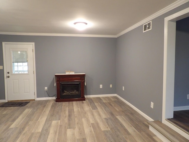 foyer entrance featuring light hardwood / wood-style floors and crown molding