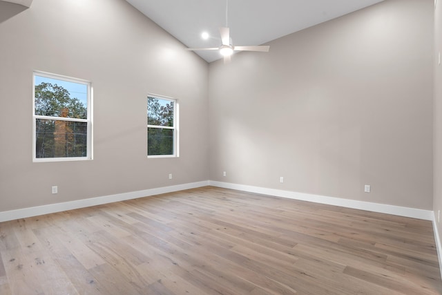 empty room featuring high vaulted ceiling, light wood-type flooring, and ceiling fan