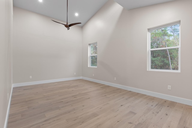 spare room featuring light wood-type flooring, a healthy amount of sunlight, and high vaulted ceiling