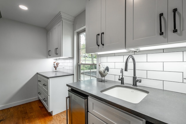 kitchen featuring wine cooler, backsplash, sink, white cabinets, and dark wood-type flooring