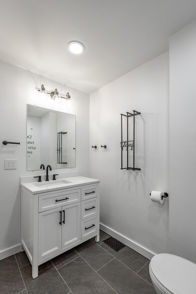 bathroom featuring toilet, vanity, and tile patterned floors