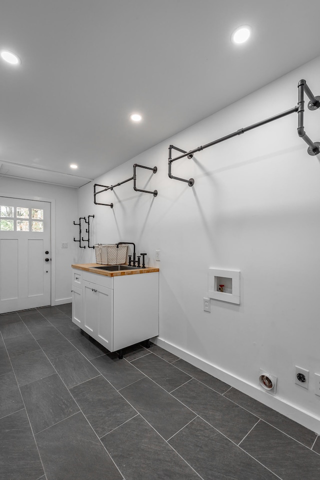 clothes washing area featuring cabinets, sink, washer hookup, electric dryer hookup, and dark tile patterned flooring