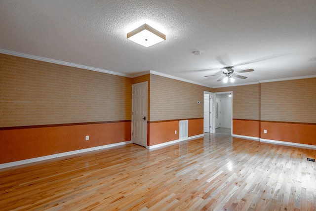 unfurnished room with ceiling fan, a textured ceiling, light hardwood / wood-style flooring, and crown molding